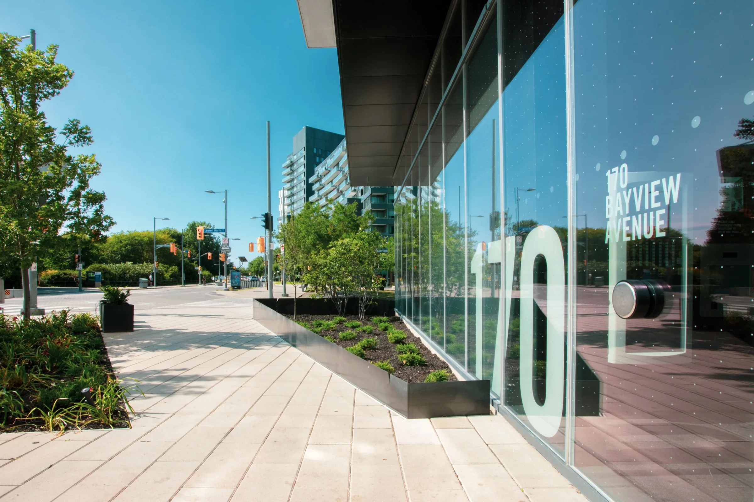 Low plantings and raised beds soften the glass frontage along Bayview Avenue