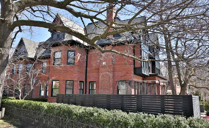 Full view of the backyard showing the complete landscape transformation with retaining walls, planters, artificial grass, and multi-level cedar deck.
