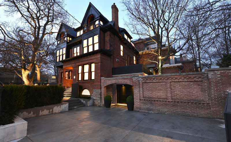 Detailed view of the property's side entrance showcasing the beautiful brick facade and architectural details that complement the traditional design.
