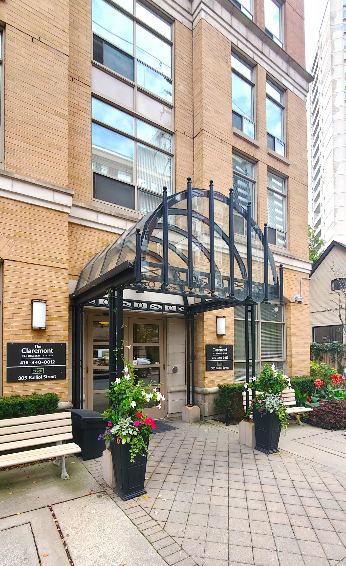 Annuals planted in urns and commercial building entrance