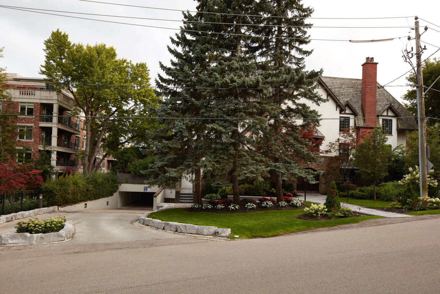 Traditional Landscape design and stonework creates welcoming entryway into underground parking space while seamlessesly blending in with surrounding nature