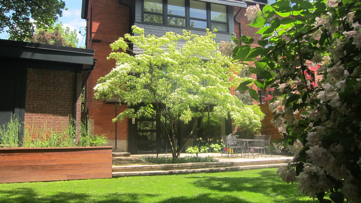 Backyard view from a different angle. Retaining wall planters, lawncare and patio stonework