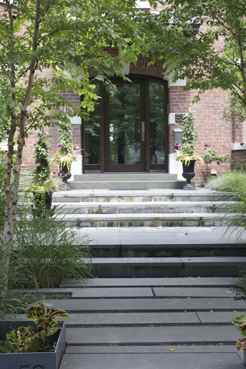 Stone walkway leading up to the front the property with garden beds on either side