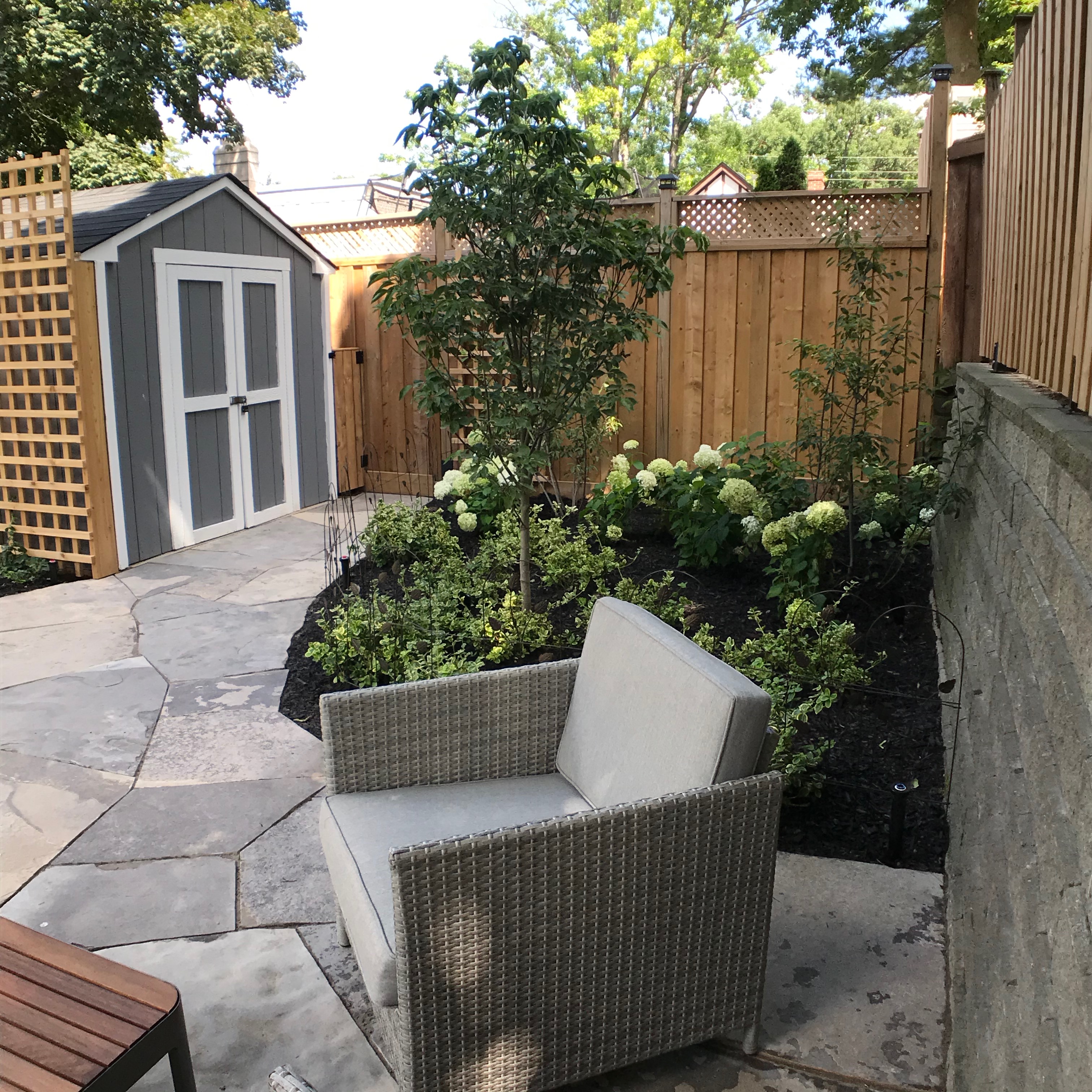 Shed with outdoor seating area next to freshly mulches outdoor area