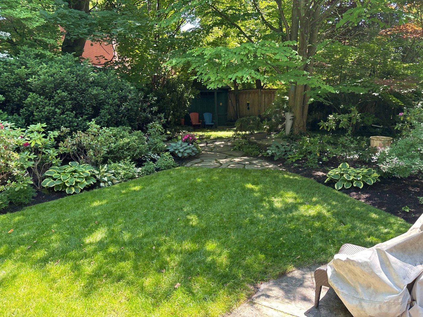 Backyard Lawn and seating area with freshly mulched garden beds