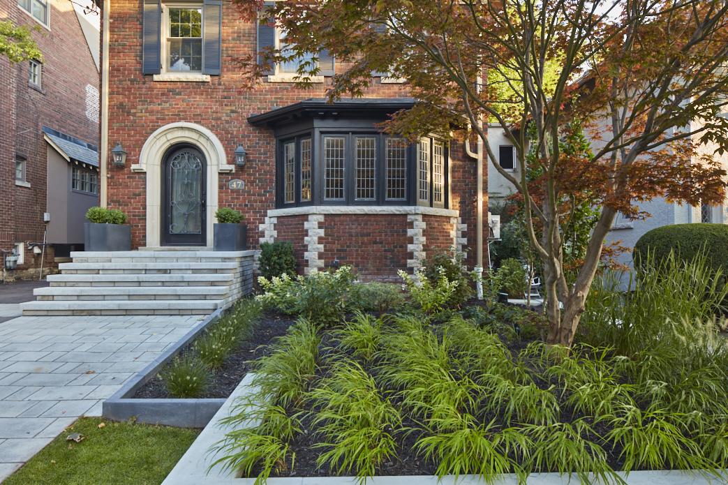 Gardens use grasses to make stonework and existing tree POP