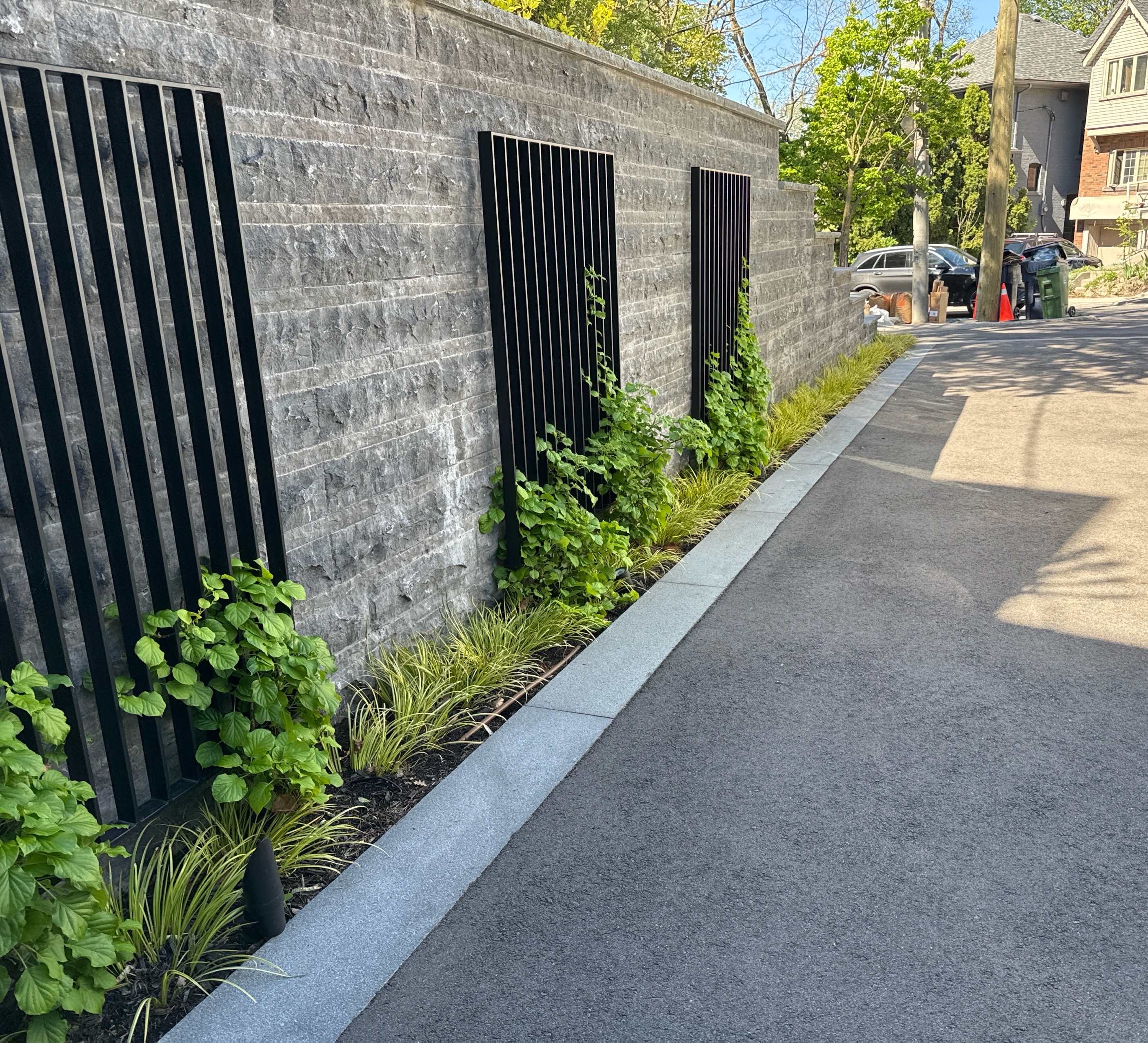 Custom Built Metal art lines driveway entrance within garden beds
