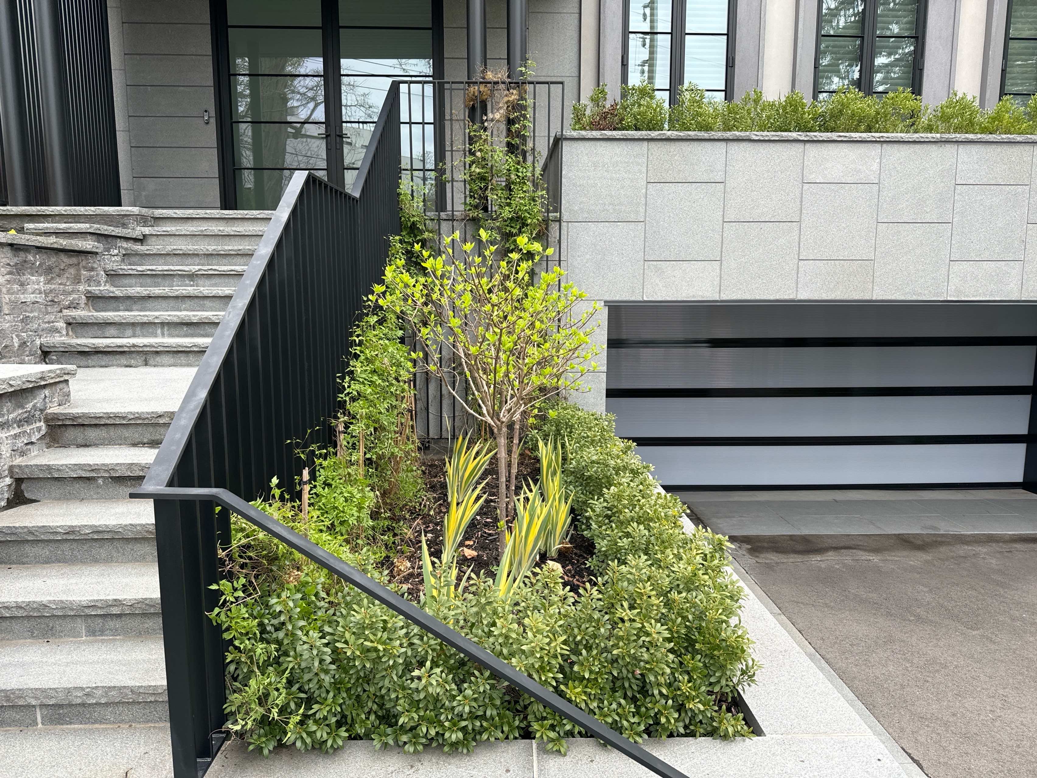Front Entrance Highlighting Garden Beds within retaining wall contains shrubs and evergreens