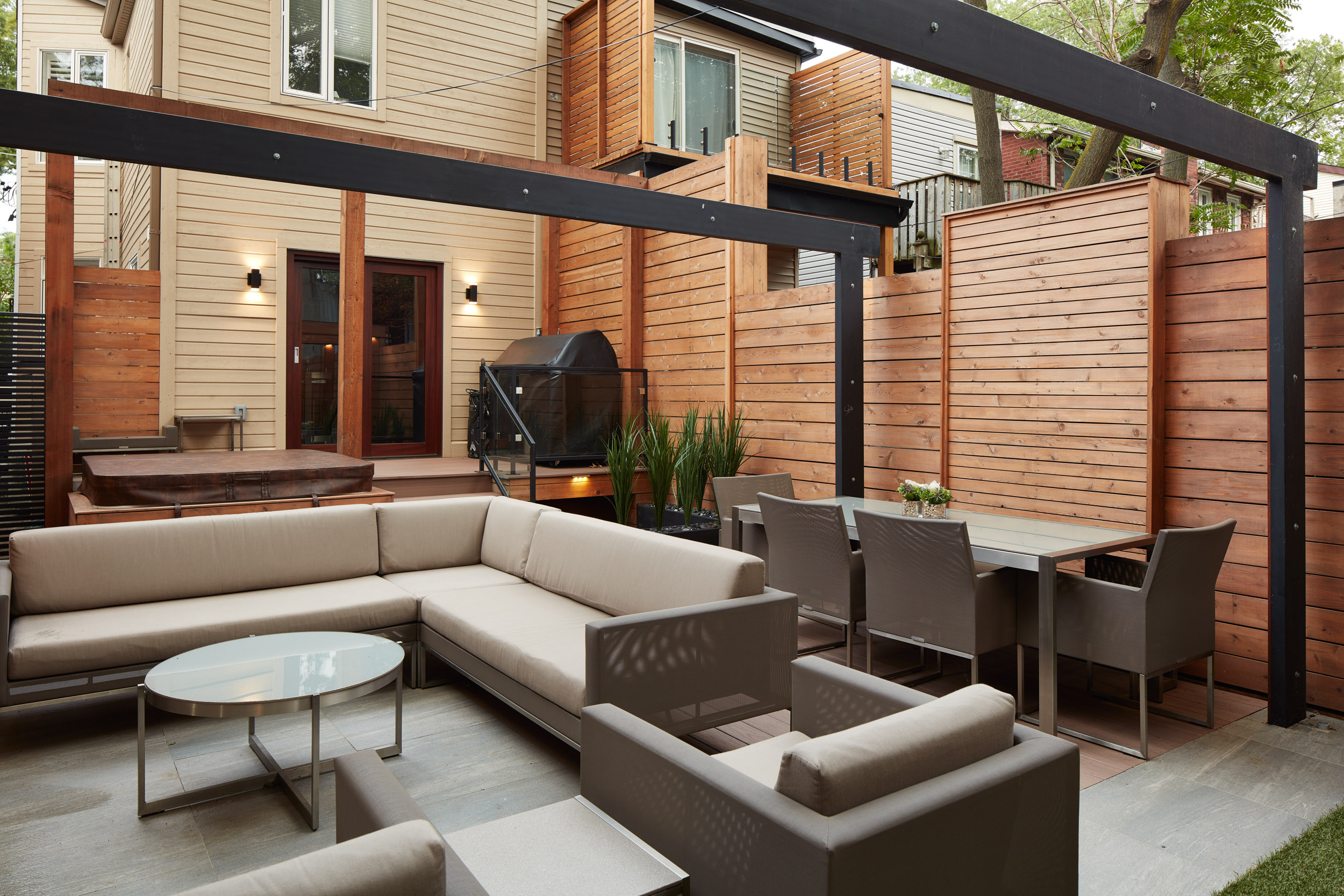 side angle view showcases the hanging lights on beams across the backyard