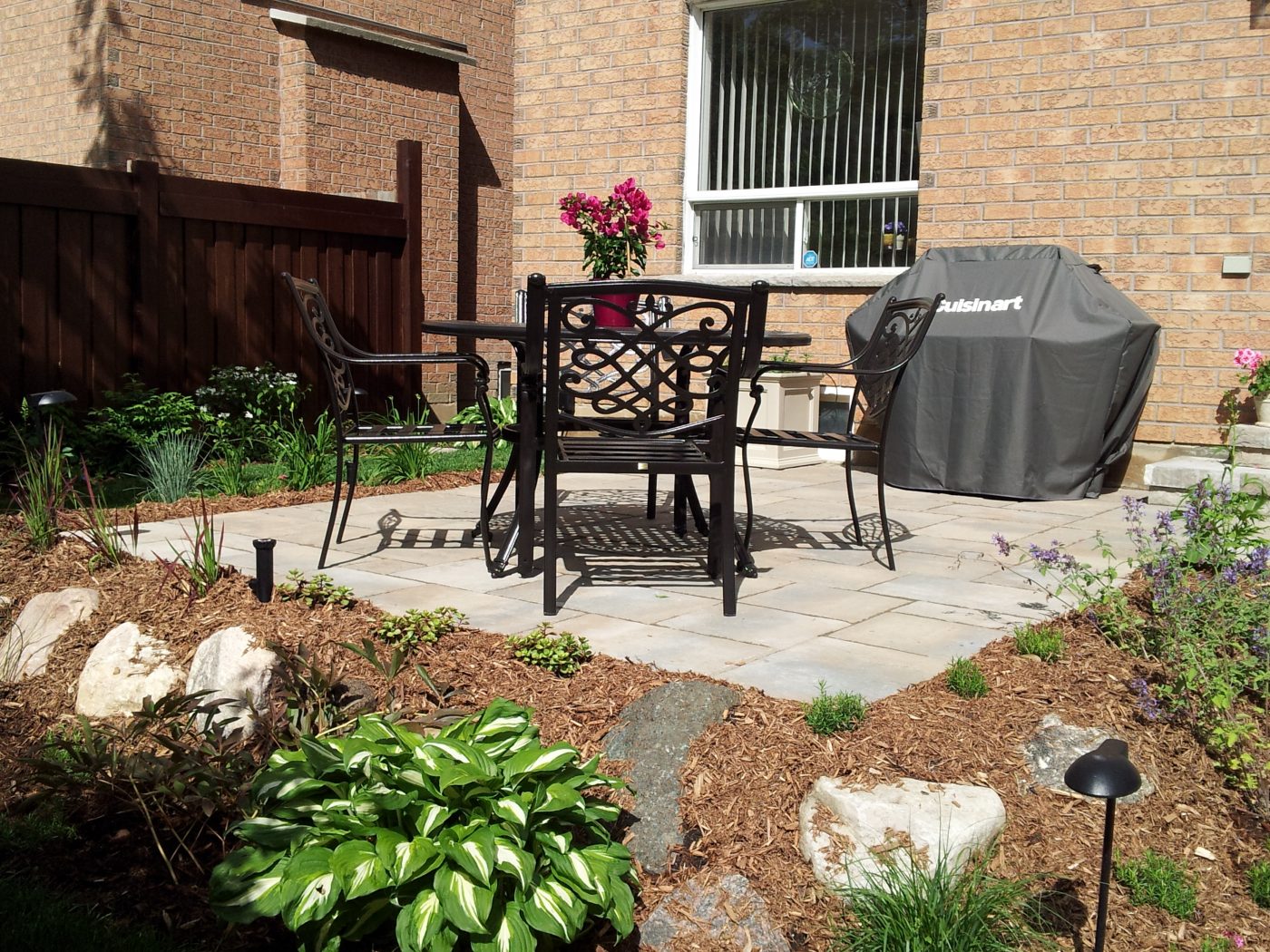 Dinner Table with chairs and BBQ on stone interlock patio