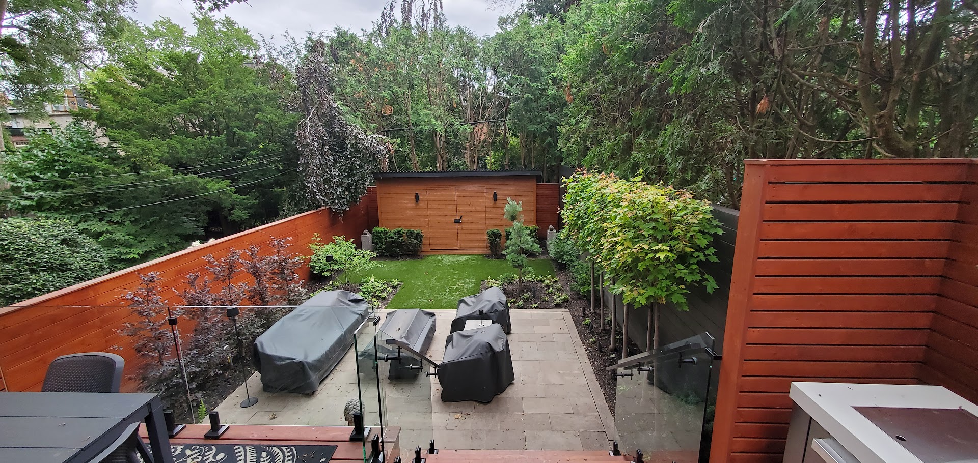 View of total backyard and hedge + Shed work with garden beds also included