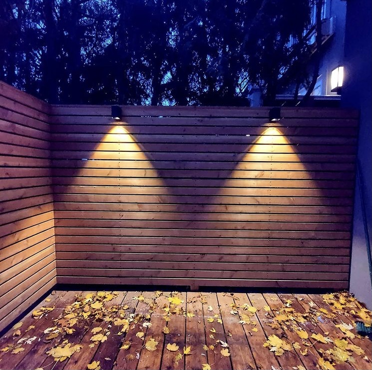 backyard lighting along custom built wooden fence