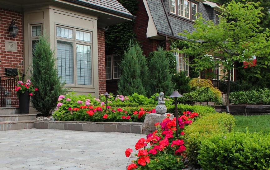 Boxwood hedge with flower bed lined in front contained by stone low hanging wall