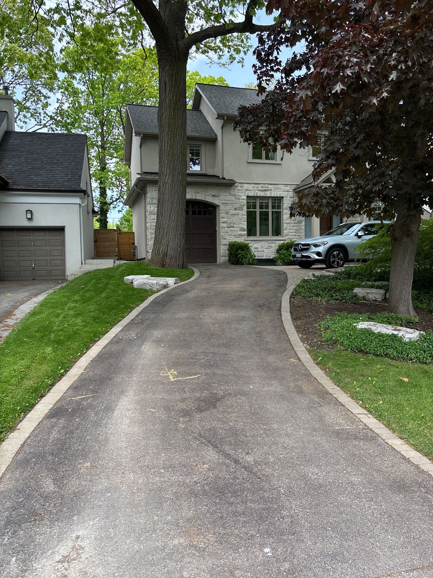 Property Driveway showcasing flower beds built around existing trees