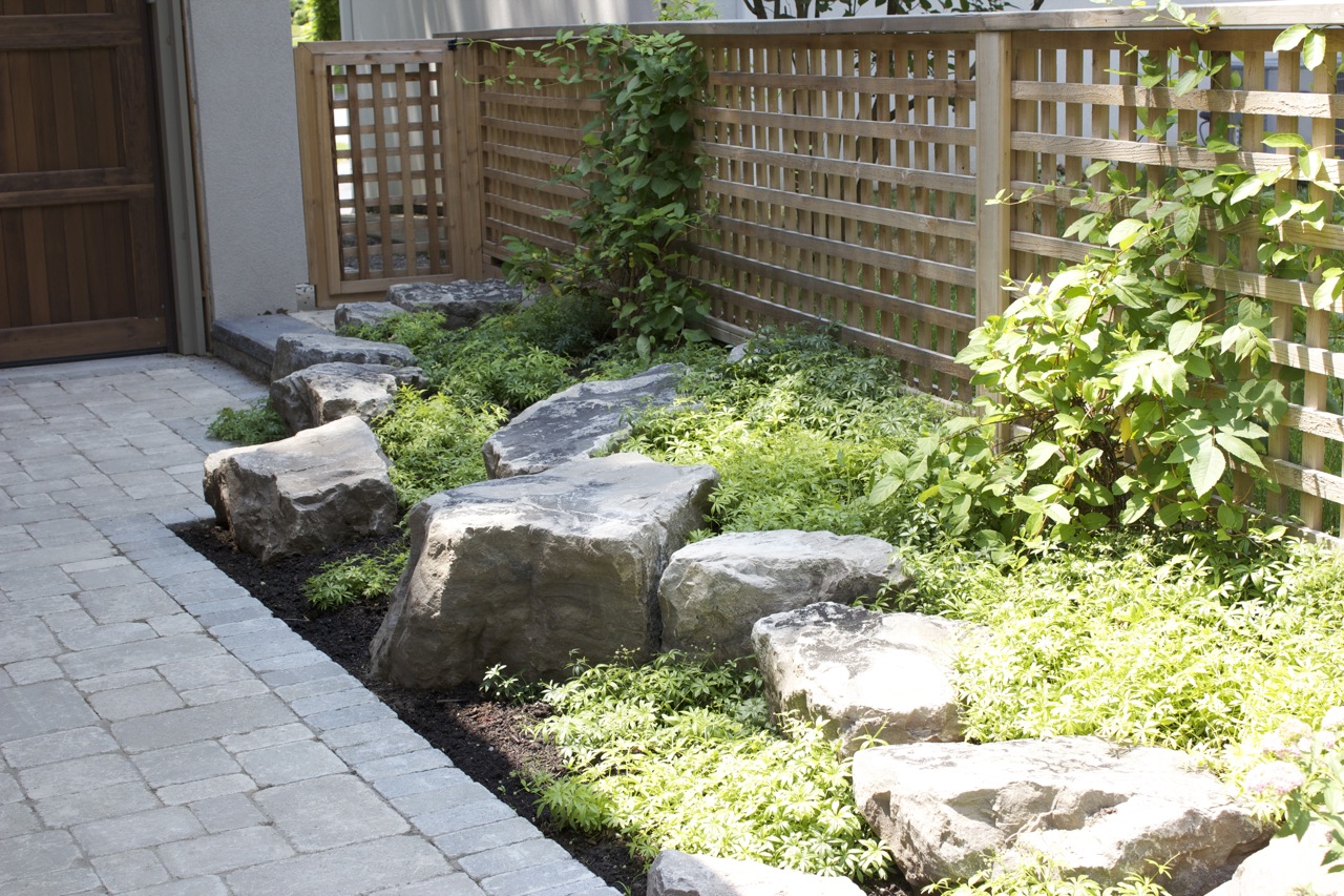 Grounder Coverage in natural stone flower bed with trellis style outward fence for plant growth