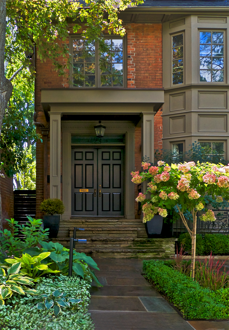 Front entryway through the boxwoods. Beautiful short trees mark the path up