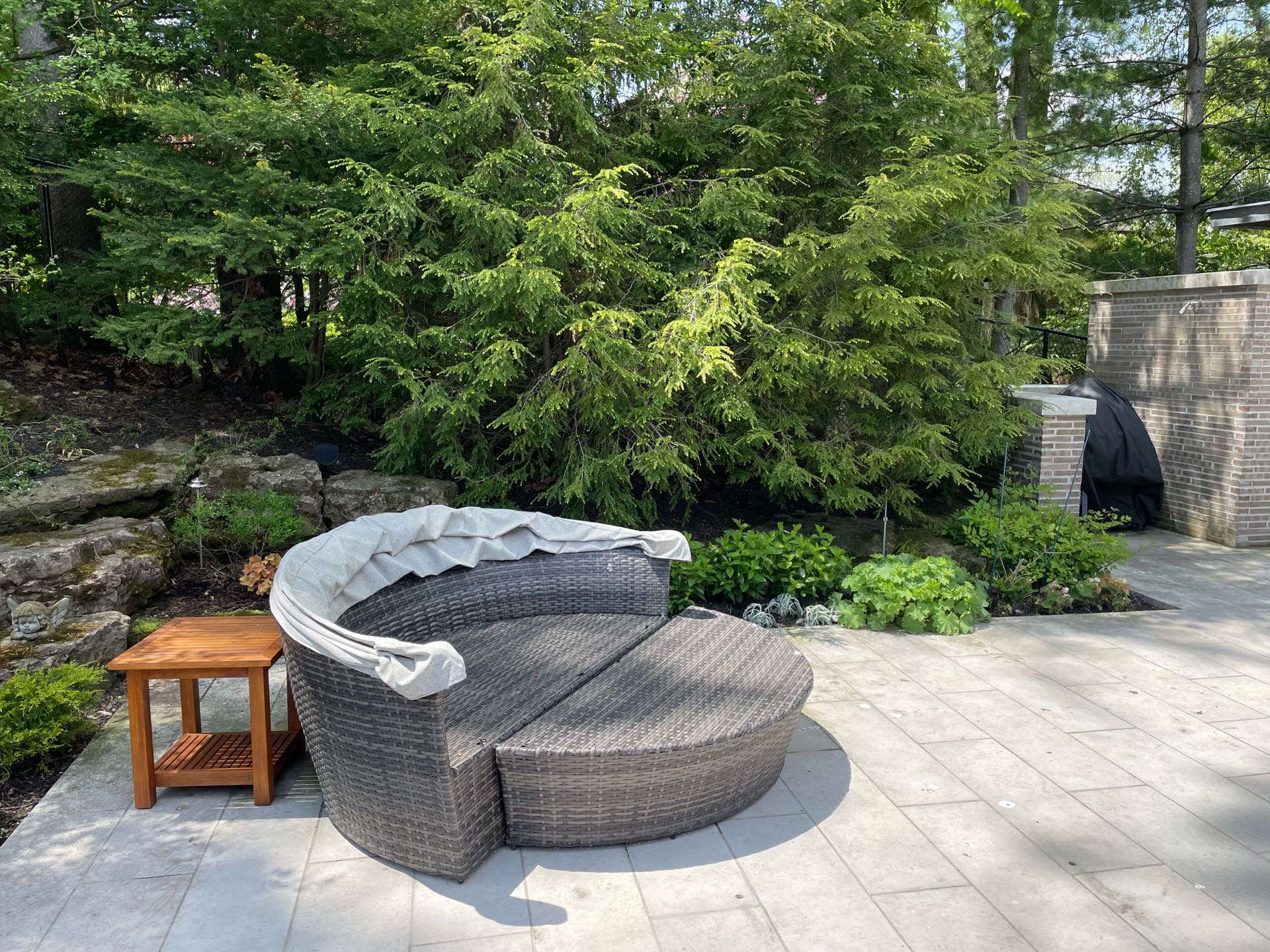 Pool side seating with built in sun protection. Custom built gardens beds fill the hill behind it