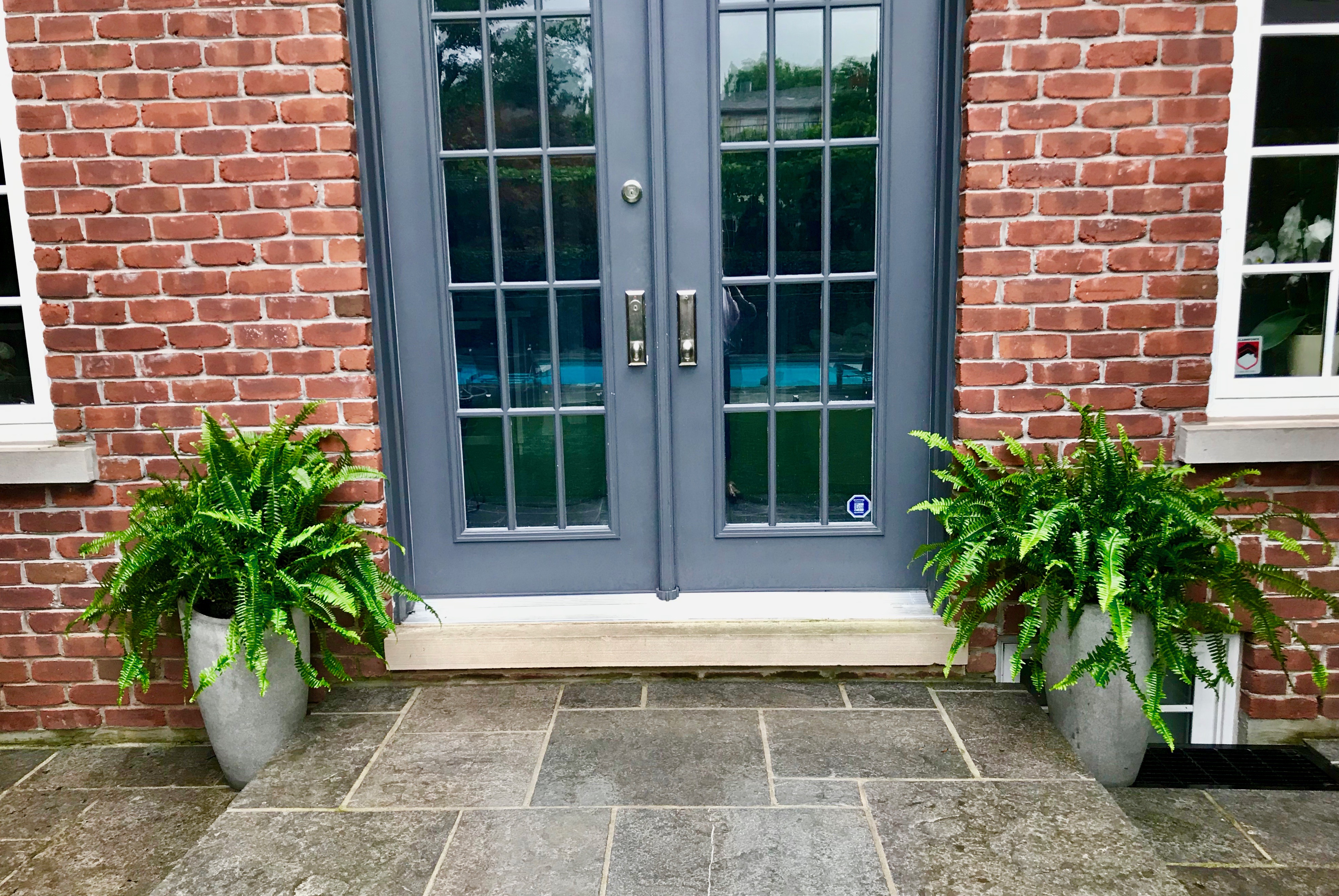 Backdoor with Fern planted large standing urns