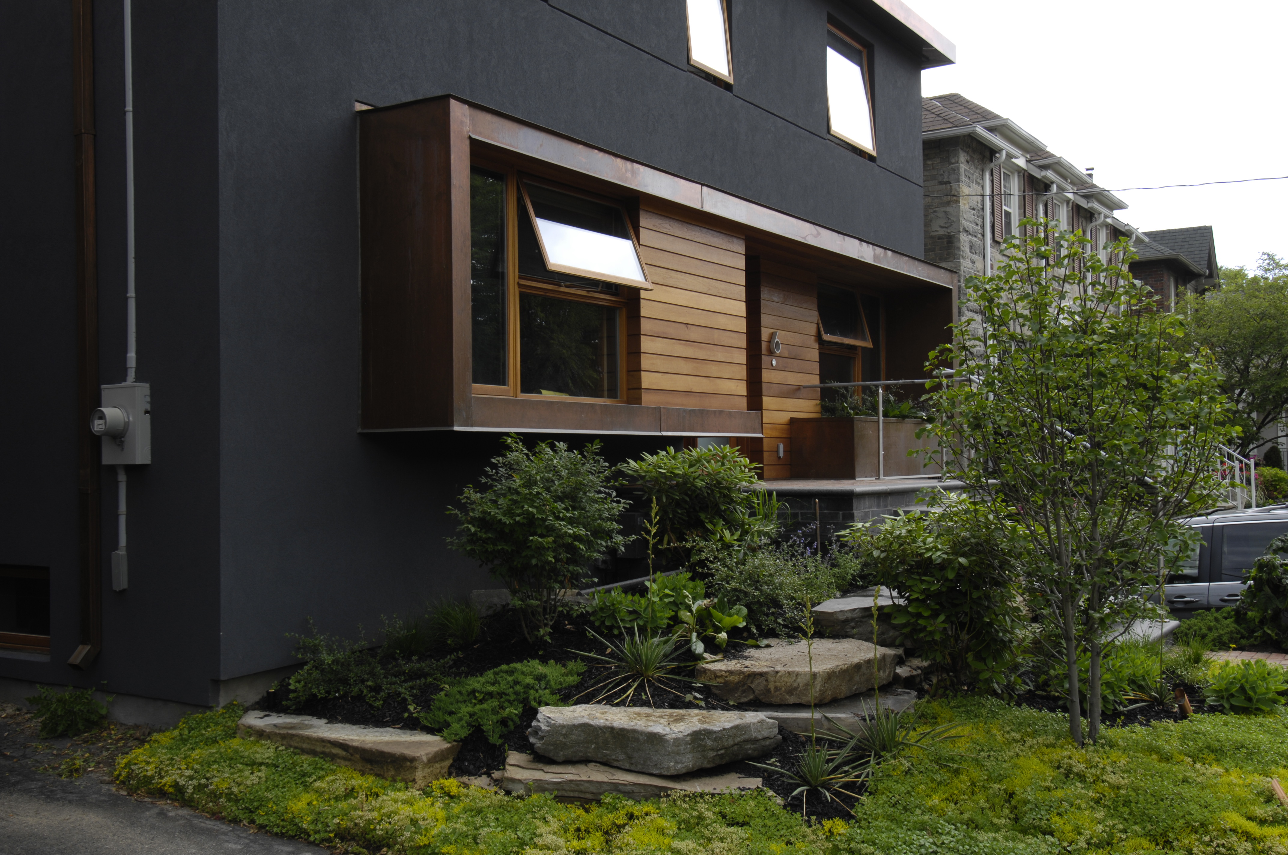 Side of the house with black mulches garden beds