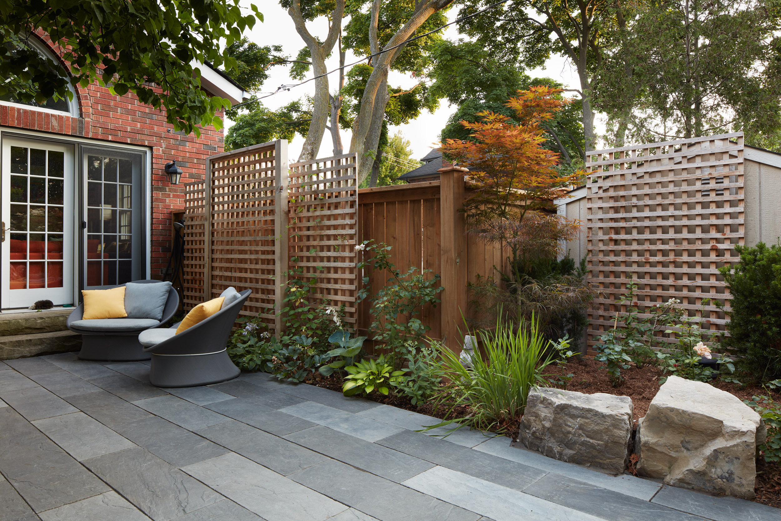 Multiple trellises line the garden beds full of natural brown mulch ready for plants to grow