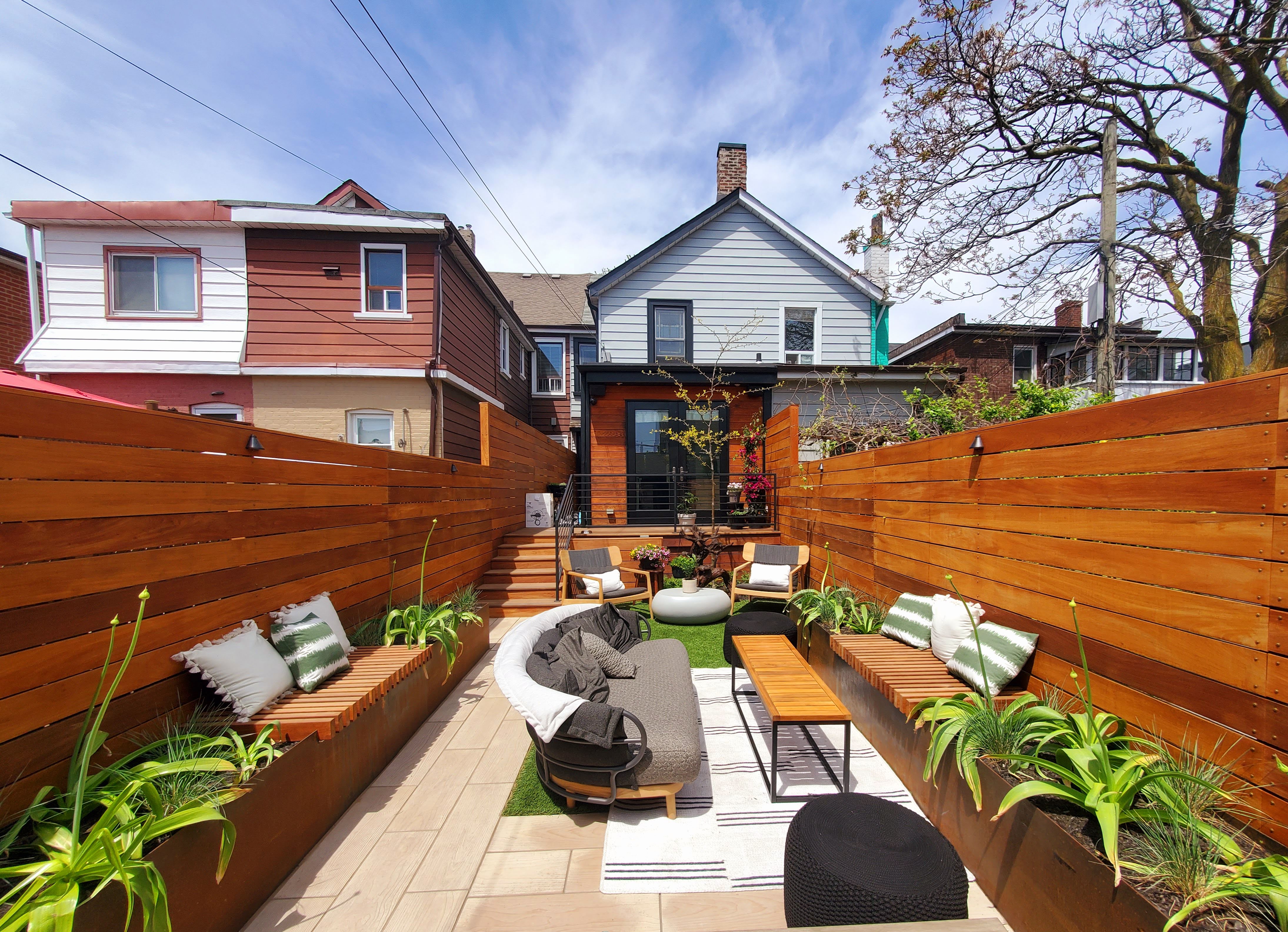 Backyard space with seating plants a deck and custom built fences
