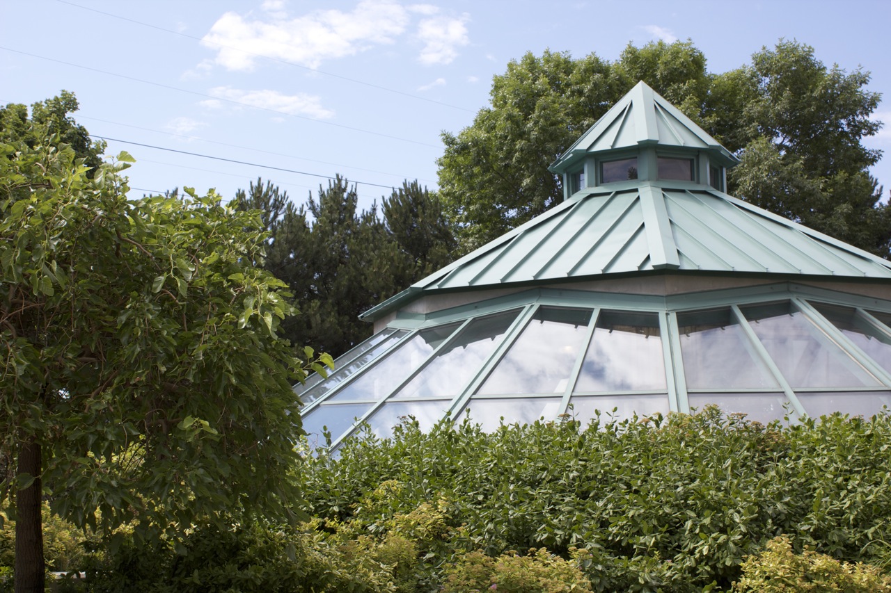 Outdoor gardens surrounding large exterior glass building