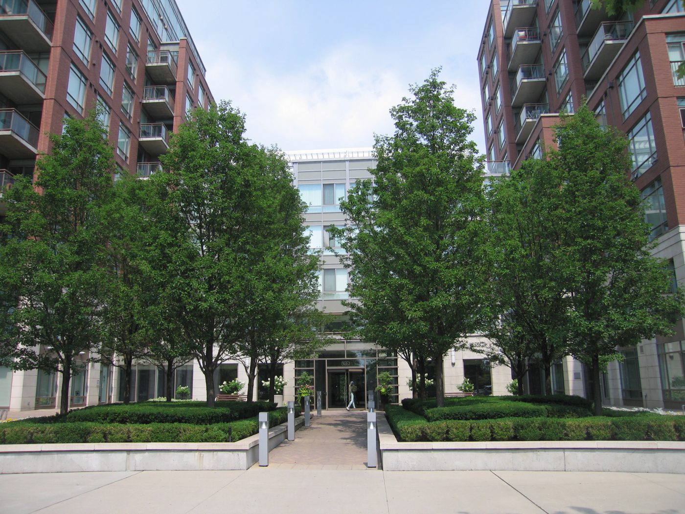 Front entrance highlighted by the specific planted trees and hedges along the sides