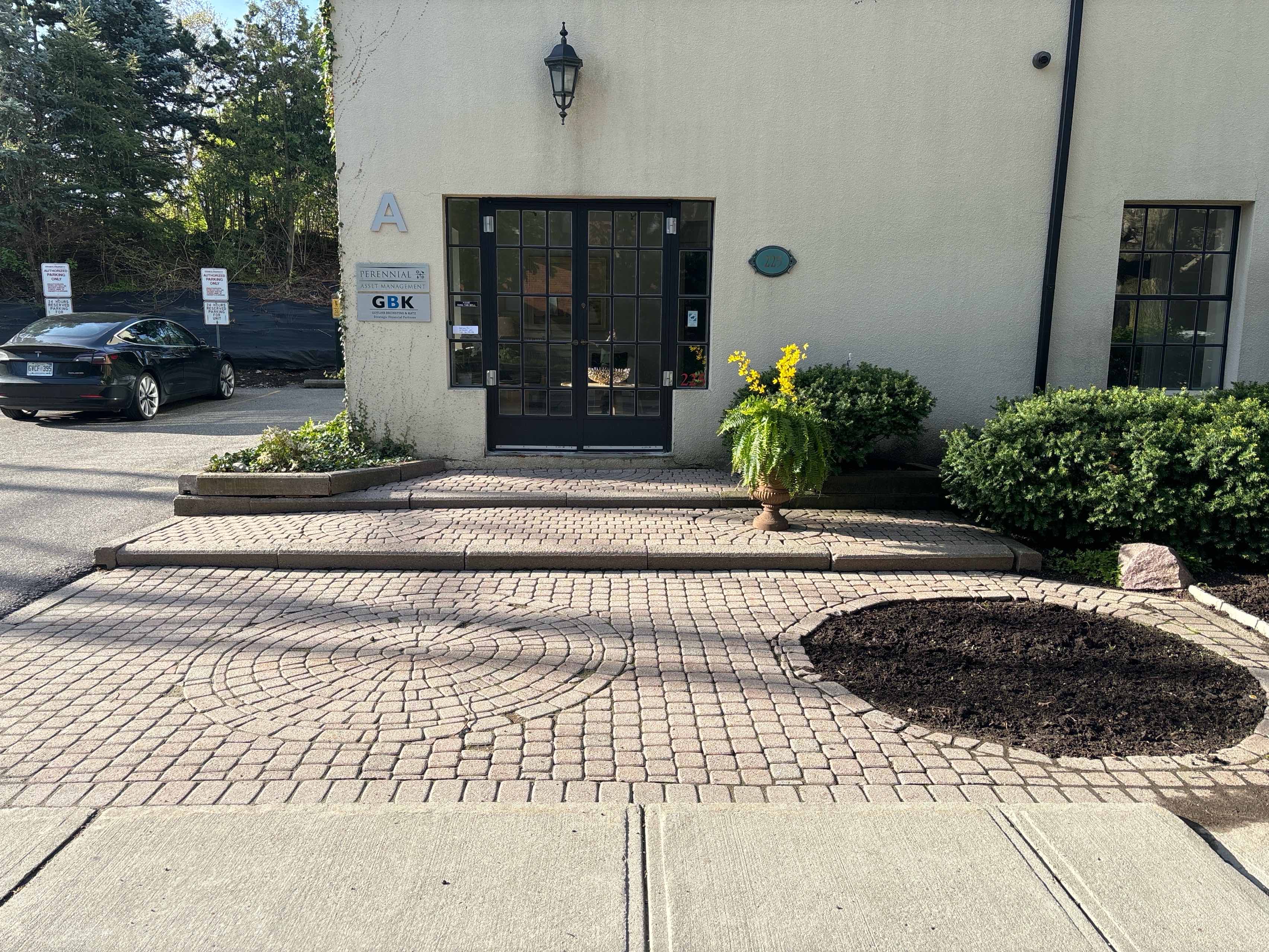 Urns, garden beds and tree shrubbery located at entrance of the property