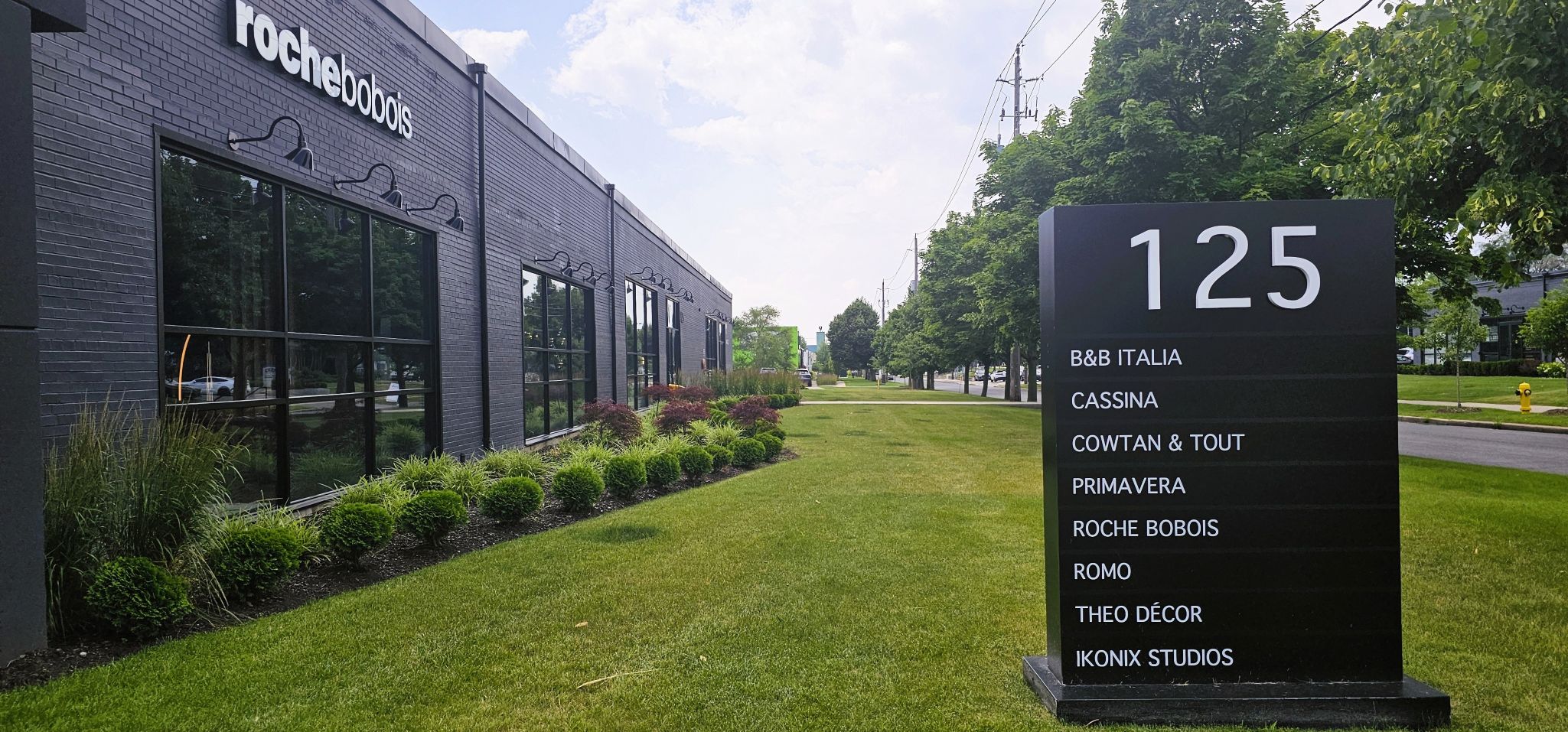 large grass area with gardens in front and along side of the building